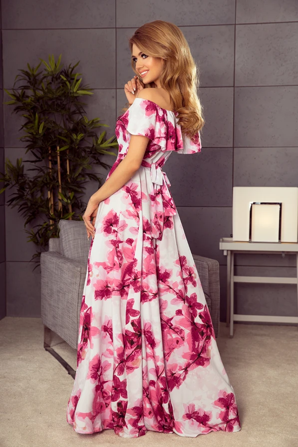 Rochia lungă cu imprimeu floral roz și alb are un design elegant, cu umeri goi și o fundă delicată la spate. Materialul fluid și croiala amplă oferă un aspect rafinat și feminin.