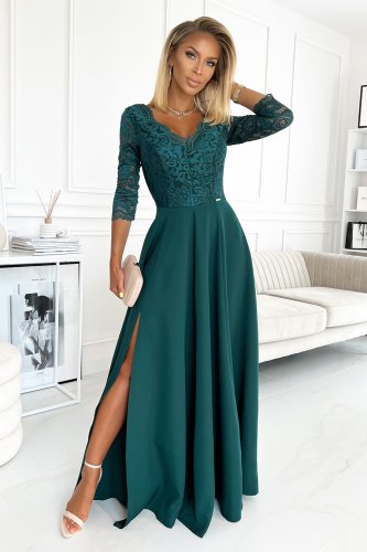 Elegancka sukienka Amber w kolorze butelkowej zieleni charakteryzuje się koronkową górą z rękawami 3/4 oraz zwiewnym, długim dołem z efektownym rozcięciem. Sukienka Amber idealnie nadaje się na wyjątkowe okazje, łącząc klasyczny styl z nowoczesnym akcentem.}