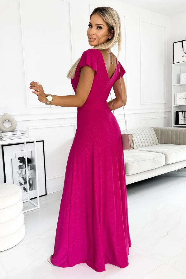 Rochia lungă, de culoare fucsia, are un design elegant cu mâneci scurte și un decolteu în formă de V la spate. Materialul strălucitor adaugă un plus de rafinament, fiind ideală pentru ocazii speciale.